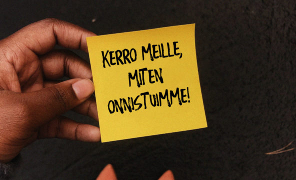 Lähikuva kädessä olevasta muistilapusta, jossa lukee kerro meille, miten onnistuimme.