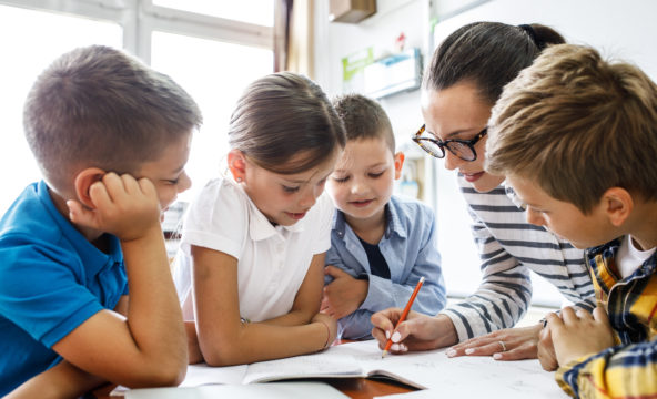 Female,Teacher,Helps,School,Kids,To,Finish,They,Lesson.they,Sitting